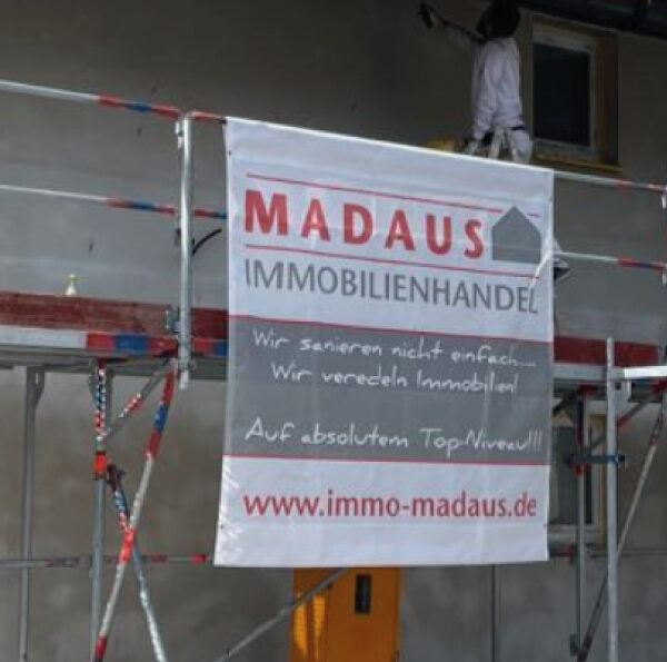 Individuell bedruckte Gerüstplane von c&w - das Werbezentrum, montiert an einem Baugerüst in der Region Geretsried.